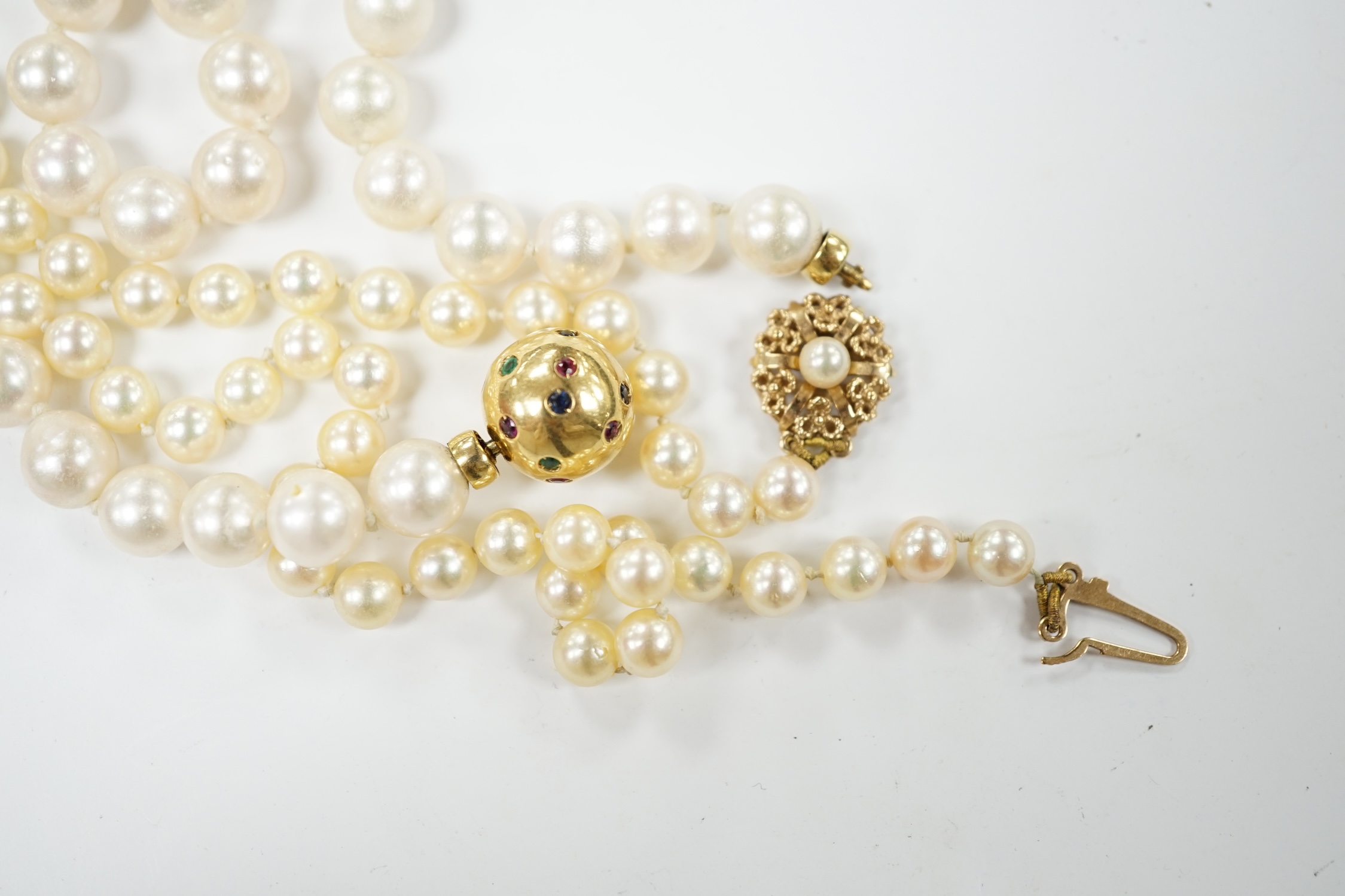 A single strand cultured pearl necklace, with 18k and multi gem set spherical clasp, 48cm, and one other single strand cultured pearl necklace, with 9ct gold and cultured pearl set clasp. Condition - fair
